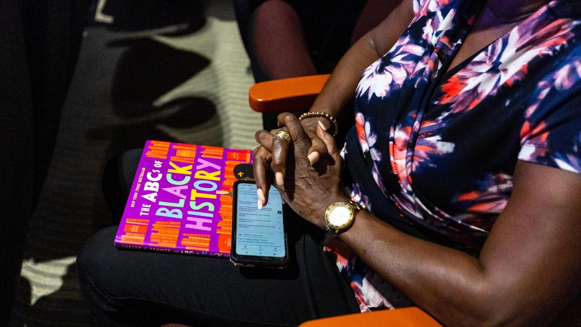 A woman holds ‘The ABC’s of Black History’ during an education town hall regarding the state’s newly adopted curriculum standards on African-American history at Antioch Missionary Baptist Church in Miami Gardens, Florida, on Aug. 10.