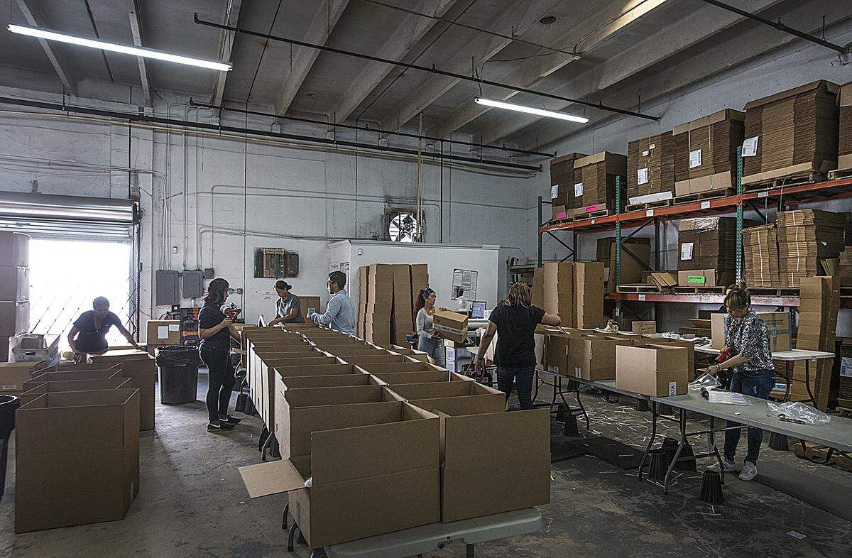 Goja employees pack boxes to ship at the Miami tech company’s offices on Tuesday, October 9, 2018.