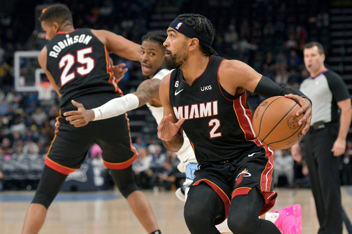 Miami Heat guard Gabe Vincent (2) handles the ball ahead of Memphis Grizzlies guard Ja Morant in the first half of a preseason NBA basketball game on Oct. 7, 2022, in Memphis, Tenn.