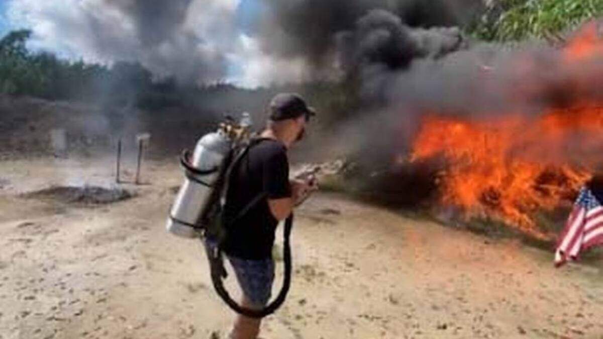 En una foto publicada en redes sociales, un hombre con un lanzallamas calcina el follaje en el campo de tiro Henry's Sport Shooting Range.
