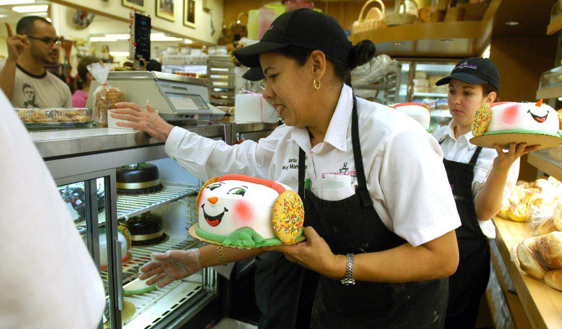 Maria Casaas, bakery manager for Epicure, helps out customers with orders of Santa cakes for the holidays.