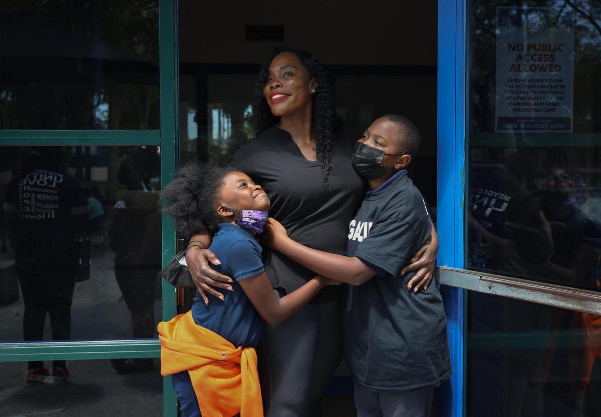 Samantha Quarterman, center, the executive director of MEYGA Learning Center, is someone who refuses to give up on her community and sees the value of educating the children. She is at the Liberty City learning center with students Gianni Mitchell, 9, left, and Quarterman’s son, Shamar Martin, 13.