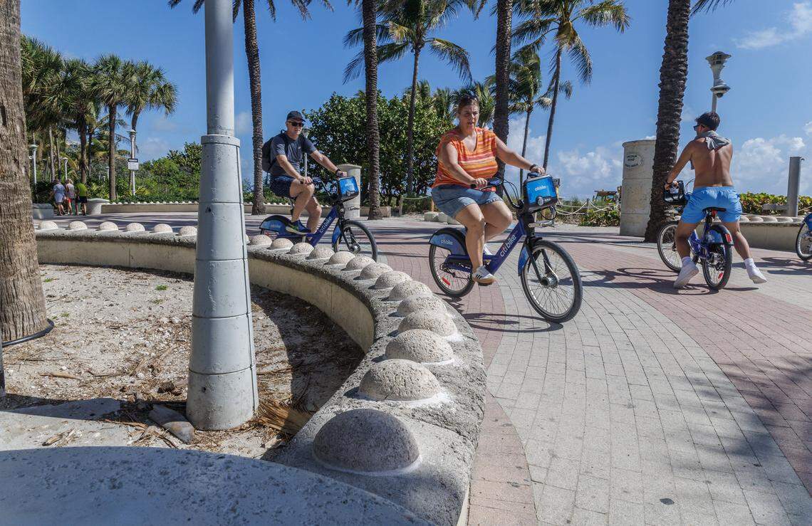 Bikers ride by round, raised concrete bumps installed by the city of Miami Beach, on low walls by the Eastern side of Lincoln Road on the boardwalk and the roundabout area, to prevent homeless people from sitting/lying down, on Tuesday, March 10, 2026.