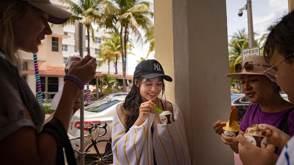 Milana Yang, center, enjoys ice cream with friends and family while the group is on a tour of American from Kazakhstan during a day over 90 degrees on Thursday, July 13, 2023, in South Beach