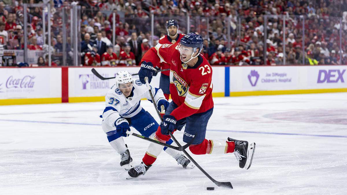 Florida Panthers center Carter Verhaeghe (23) looks to shoot the puck as Tampa Bay Lightning center Yanni Gourde (37) defends in the third period of their NHL game at the Amerant Bank Arena on Saturday, Nov. 15, 2025, in Sunrise, Fla.