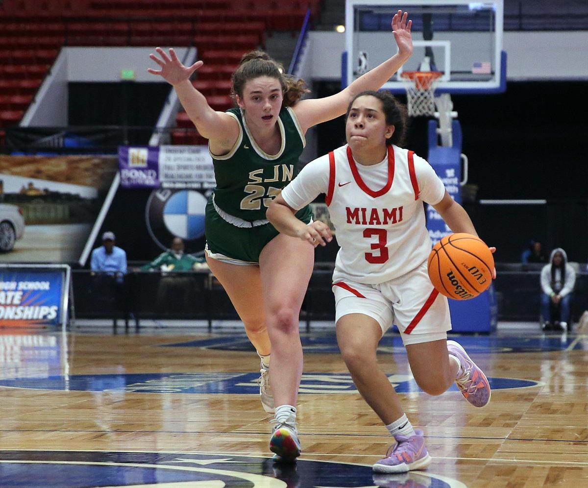 Miami Christian School guard Samantha Vales (3) drives the ball as St John Neumann High School forward Elise Flannery (23) defends during a girls basketball Class 2A state semifinal in Lakeland on Wednesday, February 23, 2022.