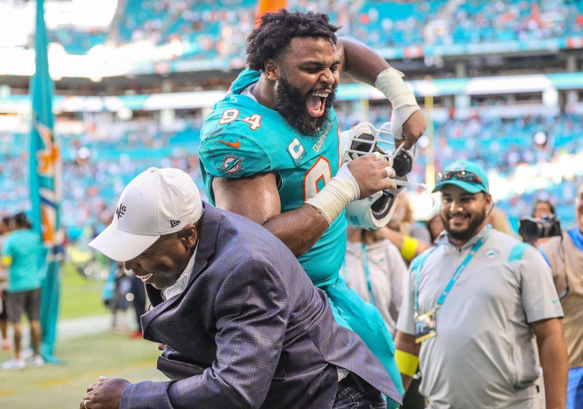 Miami Dolphins defensive tackle Christian Wilkins (94) celebrates with general manager Chris Grier after defeating the New York Jets at Hard Rock Stadium in Miami Gardens on Sunday, January 8, 2023.