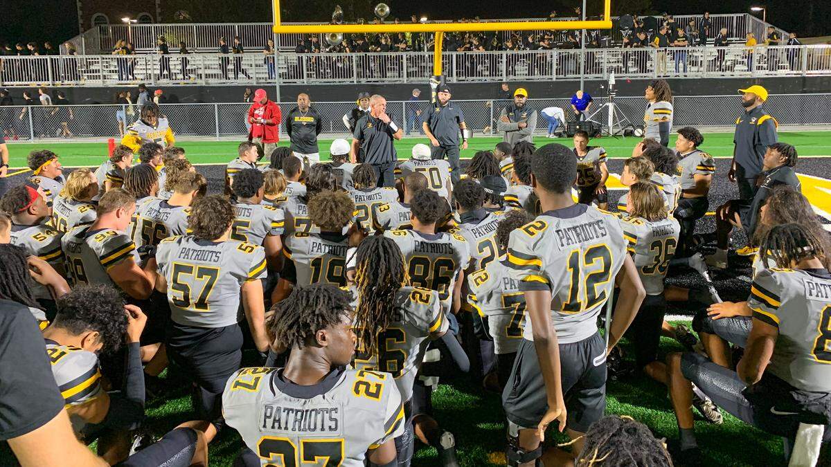 The American Heritage football team huddles together after winning its Class 2M state semifinal game against Jacksonville Bolles on Friday, Dec. 2, 2022, at American Heritage School in Plantation, Florida.
