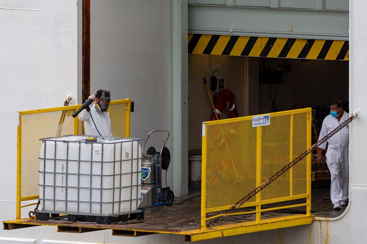 Crew members aboard Royal Caribbean’s Vision of the Seas can be seen as the ship is docked at PortMiami on Friday, May 15, 2020, in Miami, Florida.