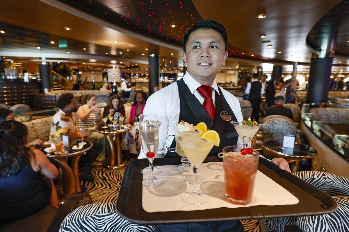 Darwin serves cocktails in the Zebra Bar on MSC Poesia at PortMiami in Miami, Florida, on Wednesday, April 22, 2026. Built in 2008, it underwent refurbishment this year. This winter, it will be based at PortMiami heading on trips to the Caribbean. Bar