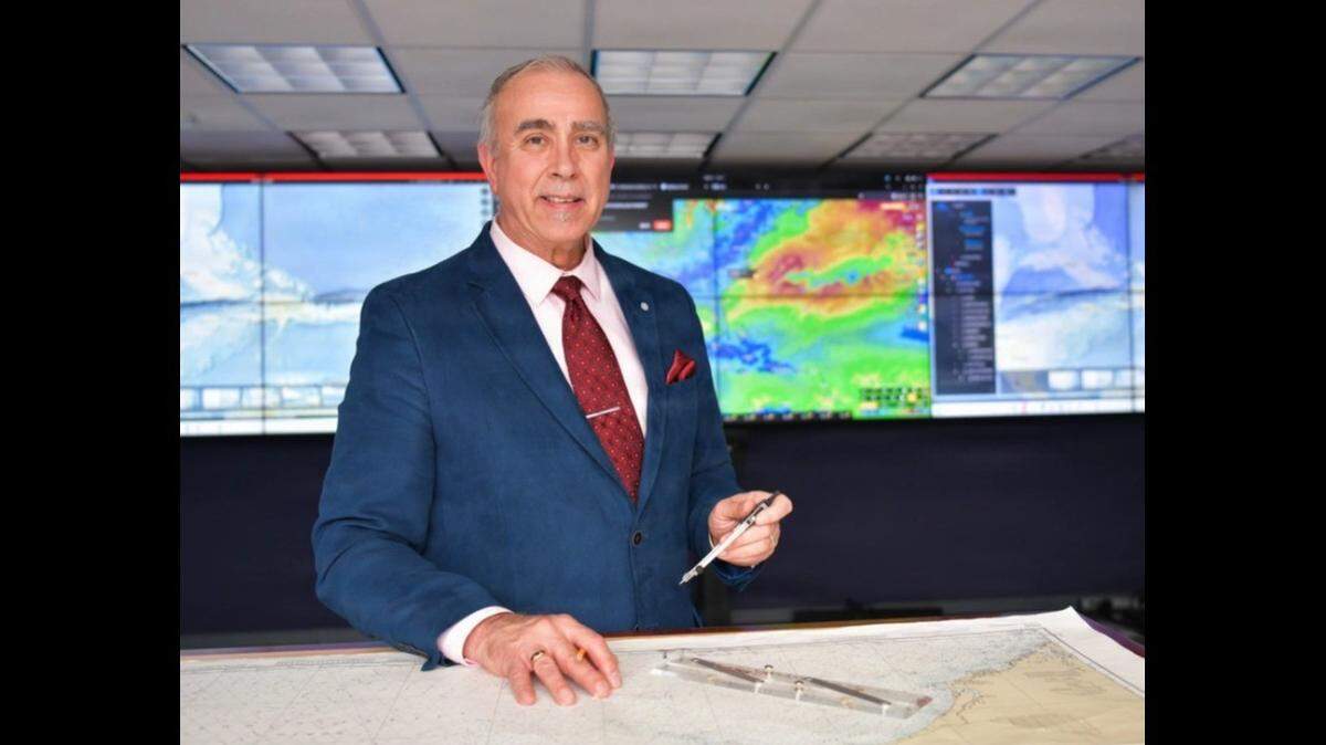 Michael Mullen poses for a photo with his compass and Weems plotter in the Coast Guard Southeast District command center in Miami on Tuesday, Dec. 9, 2025. Mullen retired Dec. 31, 2025, after serving a combined 47 years with the Coast Guard.