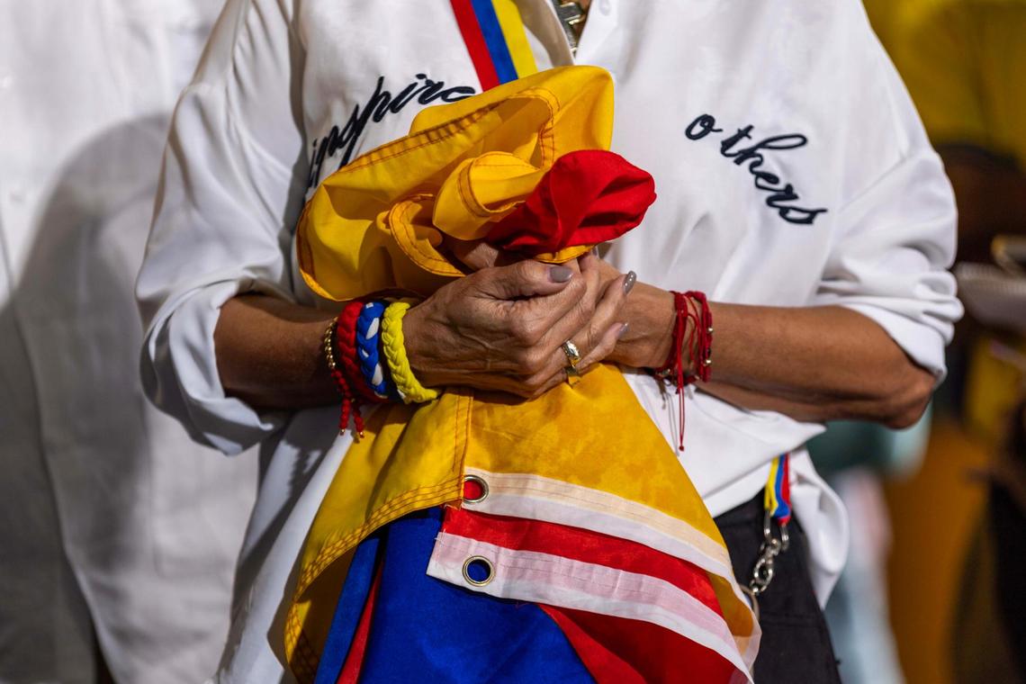A woman holds a Venezuelan flag during a press conference held by the Venezuelan American Caucus at El Arepazo on Monday, Feb. 3, 2025, in Doral.