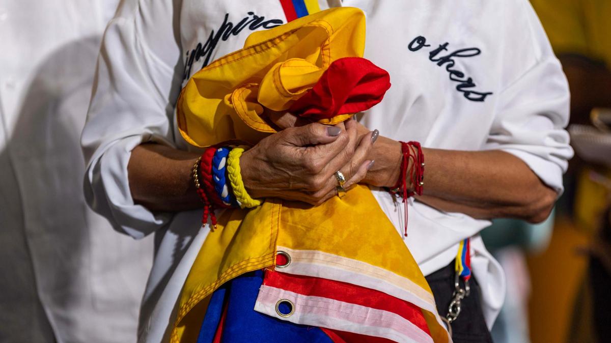 A woman holds a Venezuelan flag during a press conference held by Venezuelan American Caucus and hosted at El Arepazo on Monday, February 3, 2025, in Doral, Fla.