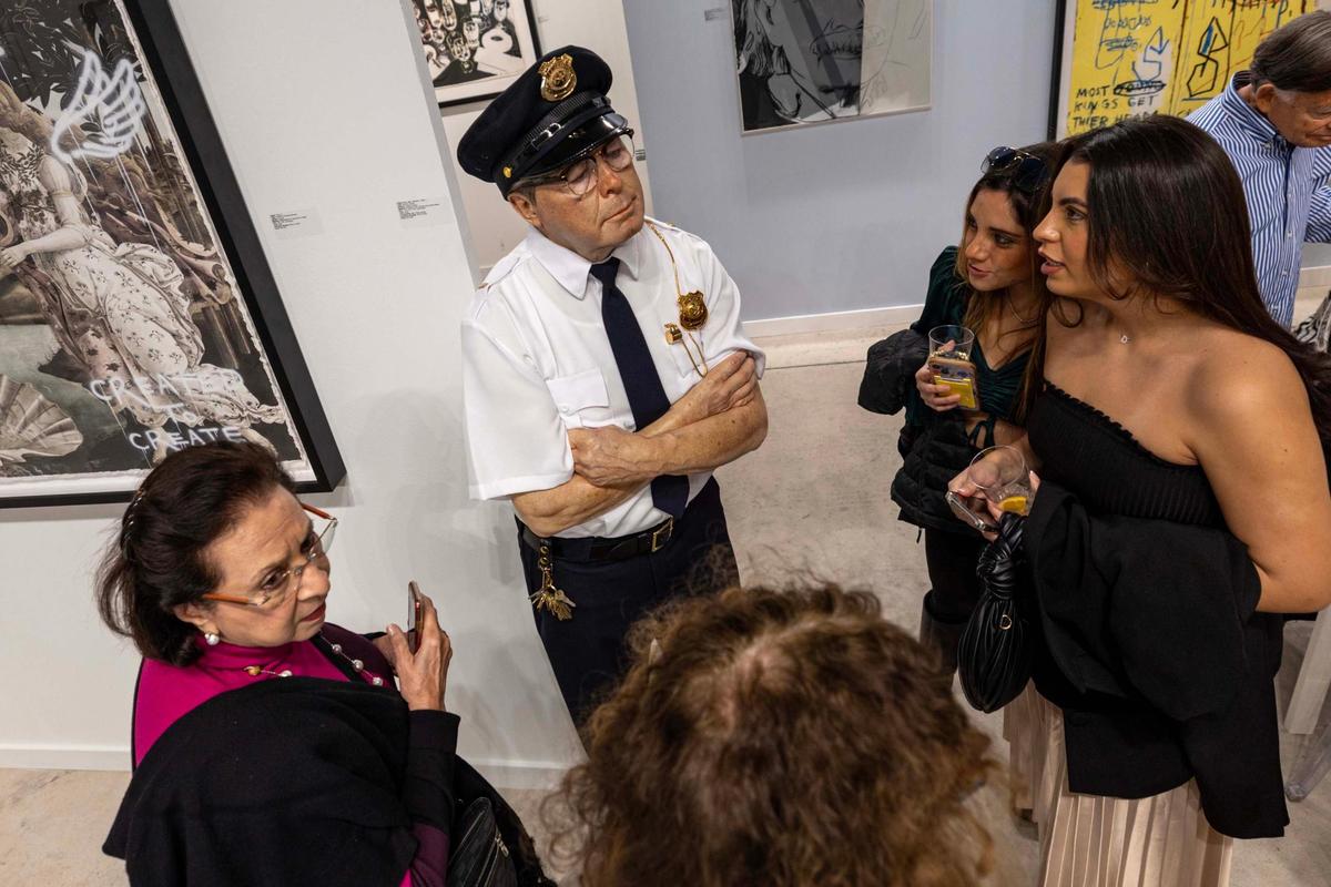 Guests look on in disbelief at a sculpture titled ‘Security Guard’ by Marc Sijan on display during Art Miami at One Herald Plaza on Tuesday, Dec. 3, 2024, in Miami, Fla.