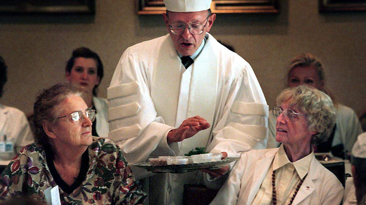 In an archival photo from 2021, Rabbi Solomon Schiff explains the Seder foods. to patients at Mount Sinai Medical Center on Miami Beach.