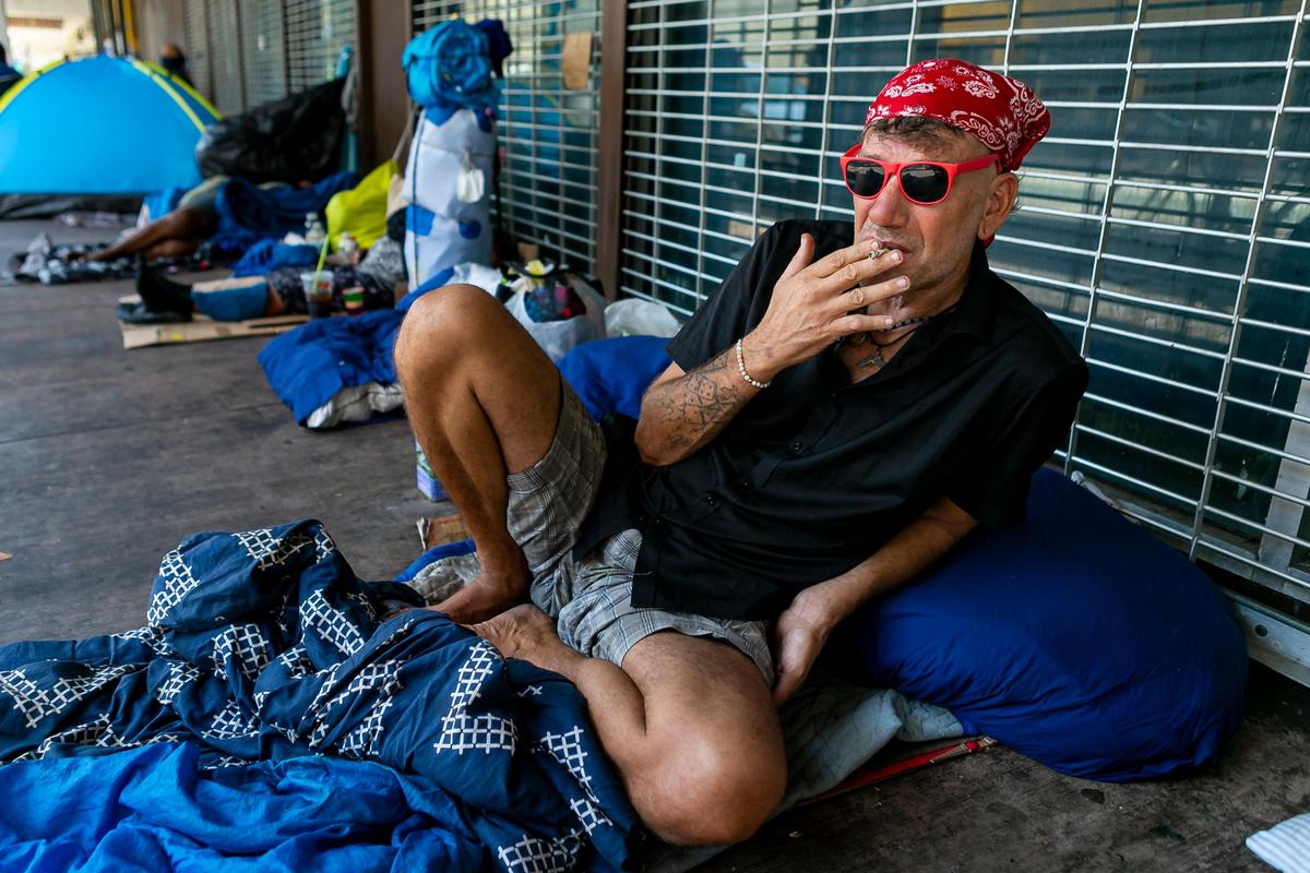 Star Lee Black, 50, smokes a cigarette near South Miami Avenue and Southwest 1st Street in downtown Miami as concerns over COVID-19 continue to spread through South Florida on Tuesday, April 14, 2020.