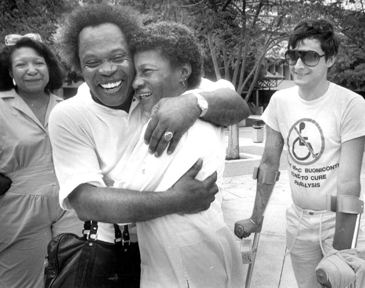 Singer Sam Moore, the Sam half of the 1960s singing group Sam & Dave, hugs nurse Rozella White. Moore, born in Miami, gave a free concert at Jackson Memorial Hospital in 1986.