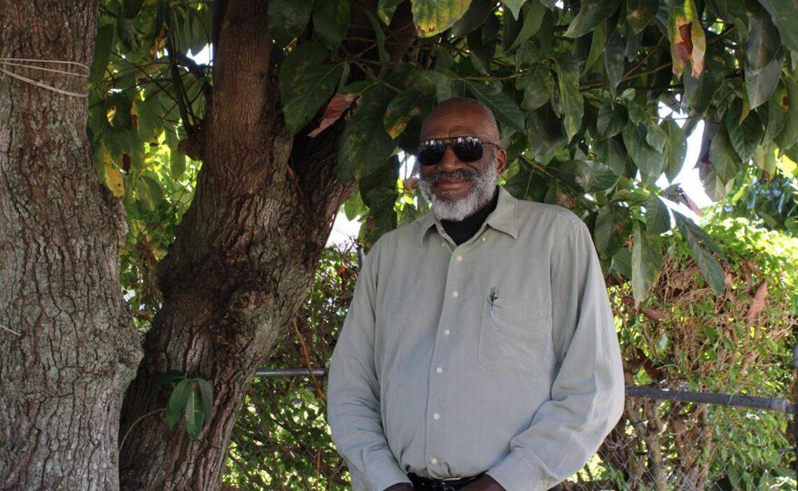 Carl Leon standing next to the avocado tree he planted as a kid.