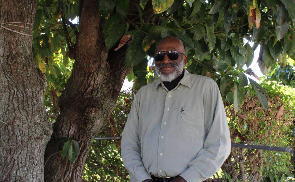 Carl Leon standing next to the avocado tree he planted as a kid.