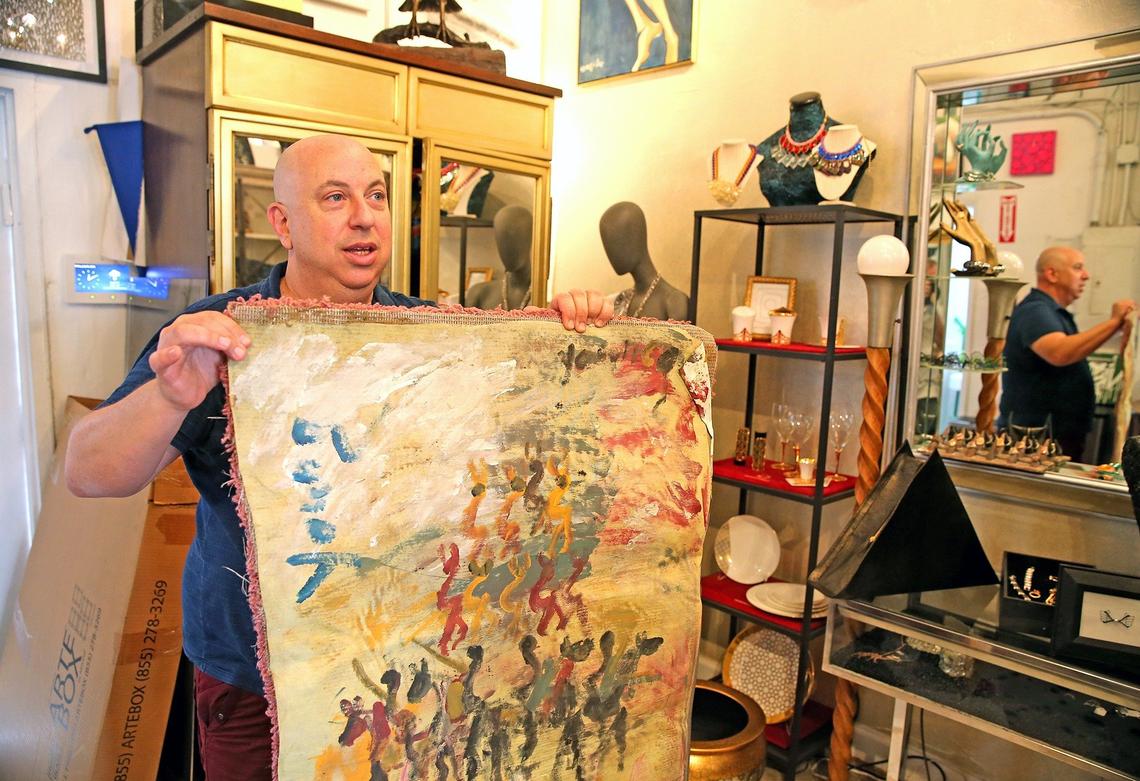 Gallery owner Moti Vinograd holds art by artist Purvis Young in his gallery, Casa Mondo, in North Miami.