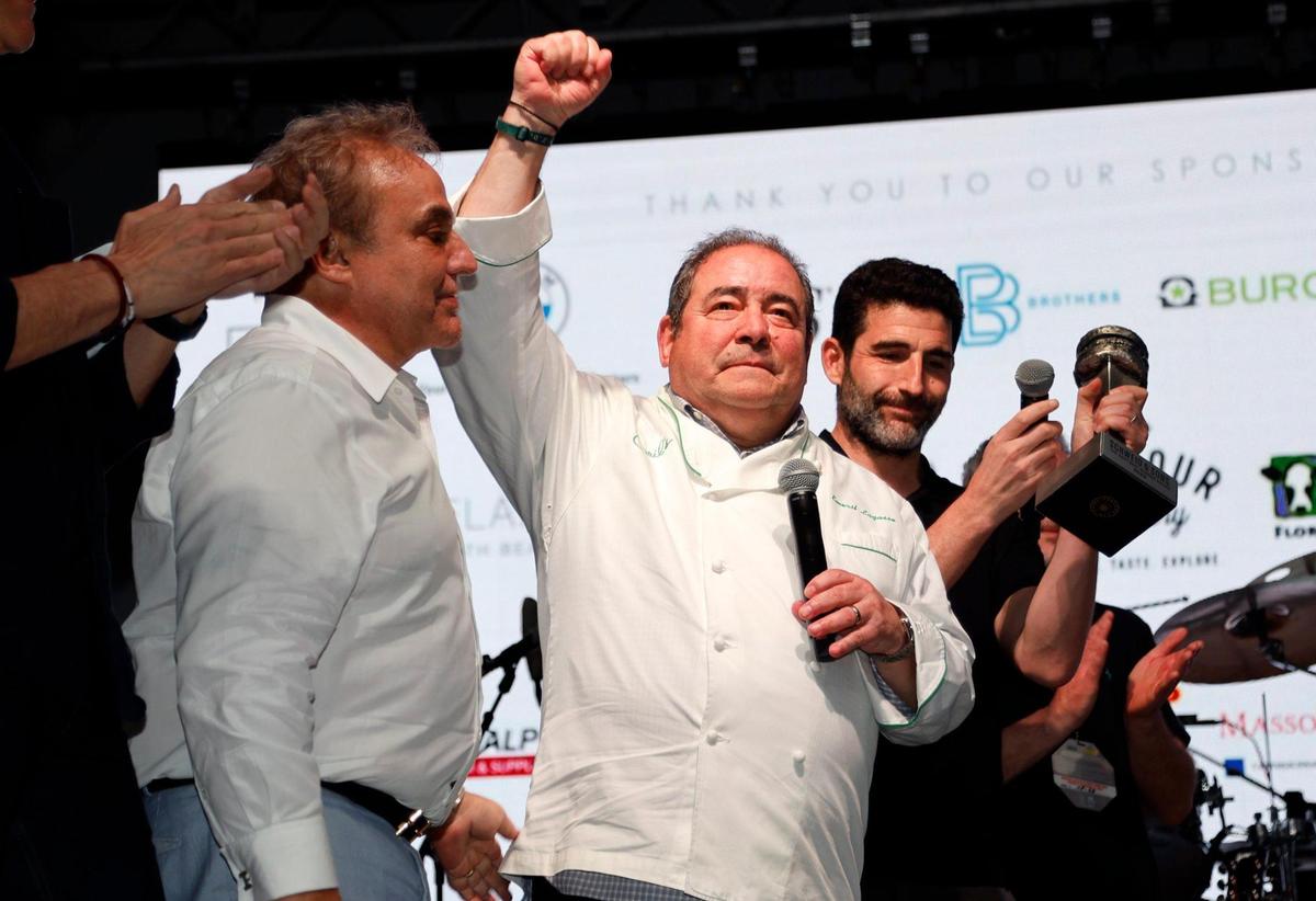 American celebrity chef, restaurateur, and television personality, Emeril Lagasse reacts as he arrives on stage at the South Beach Wine & Food Festival. The event founder, Lee Schrager is at left, during the Burger Bash at the South Beach Wine & Food Festival on the sand by the Ritz Carlton in Miami Beach, Florida on Thursday, Feb. 23, 2023.