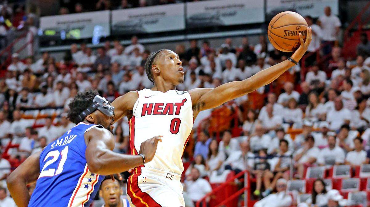 Heat small forward Josh Richardson leaps past Philadelphia 76ers center Joel Embiid for a basket in the first quarter in Game 4 of the first round of the NBA Playoffs at the AmericaneAirlines Arena in Miami, Florida, on April 21, 2018.