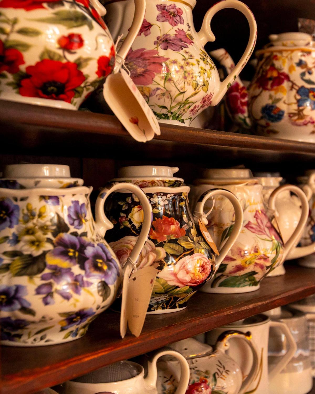 Assorted tea pots sit on shelves before use inside The Tea Room at Cauley Square.