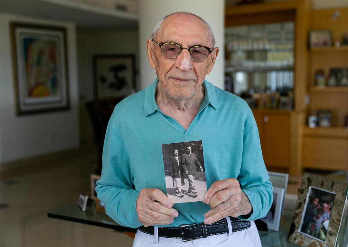 Holocaust survivor Jack Waksal, 97, holds a photo of him and his late wife, Sabina, in his apartment in Bal Harbour, Florida, on Tuesday, April 26, 2022.