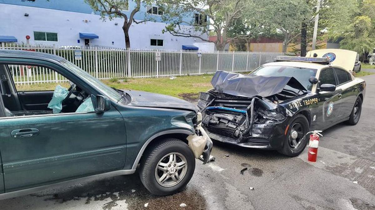 An unidentified driver has been charged with almost hitting a Florida Highway Patrol trooper and crashing into a patrol car in Miami Gardens.