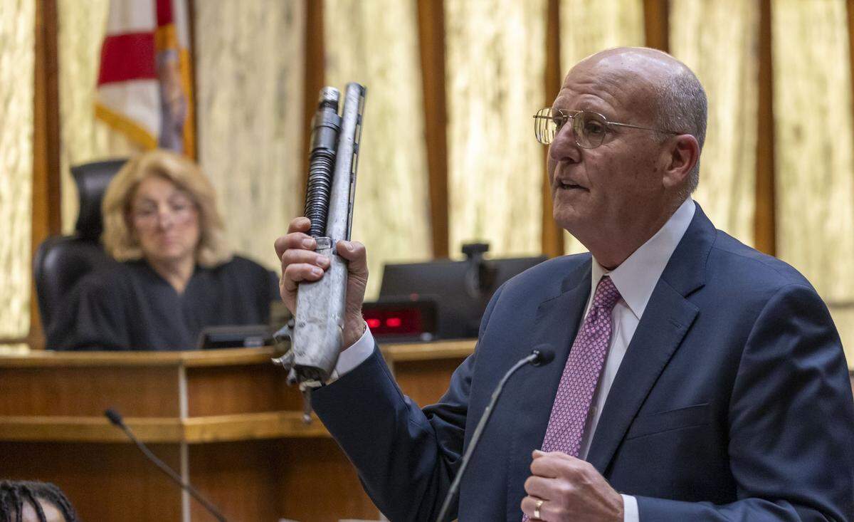 Miami, FL, November 5, 2025 - Prosecutor Joshua Weintraub, right, holds up a piece of evidence as he delivers closing arguments during the trial of Labrant Dennis who was convicted in 1998 of killing Timwanika Lumpkins, his ex-girlfriend, and UM linebacker Marlin Barnes.