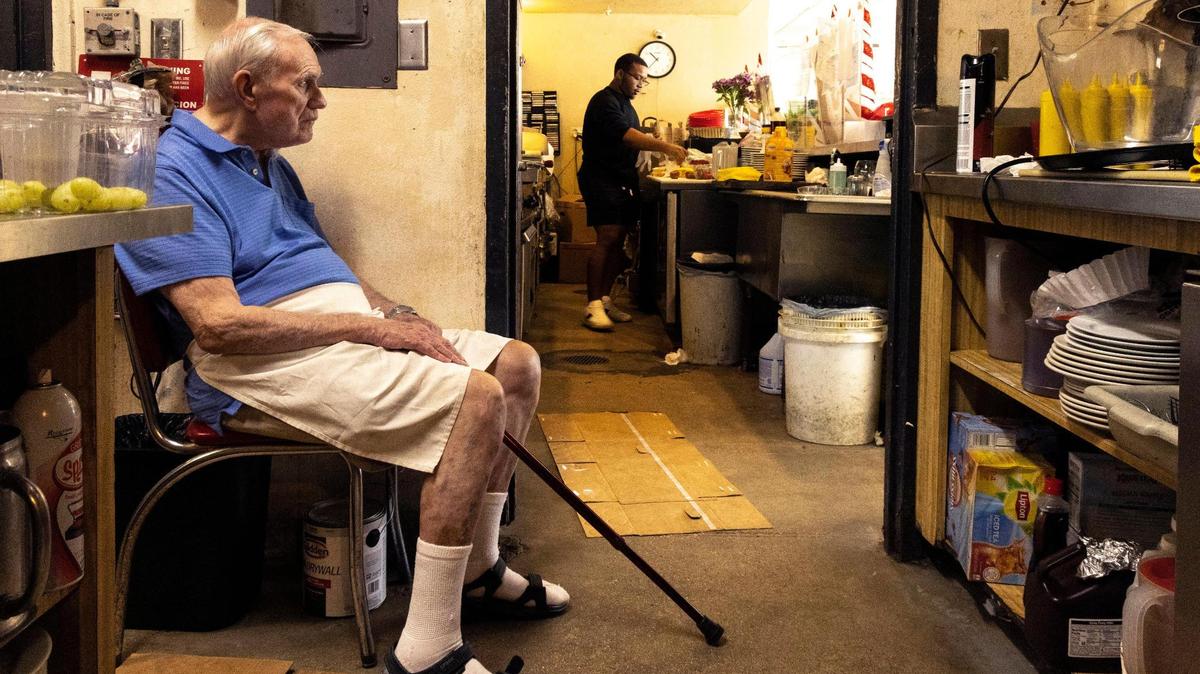 Bob Maguire, 85, sits as Corey Tennyson, 20, his partner’s son, works near the grill at Burger Bob’s.