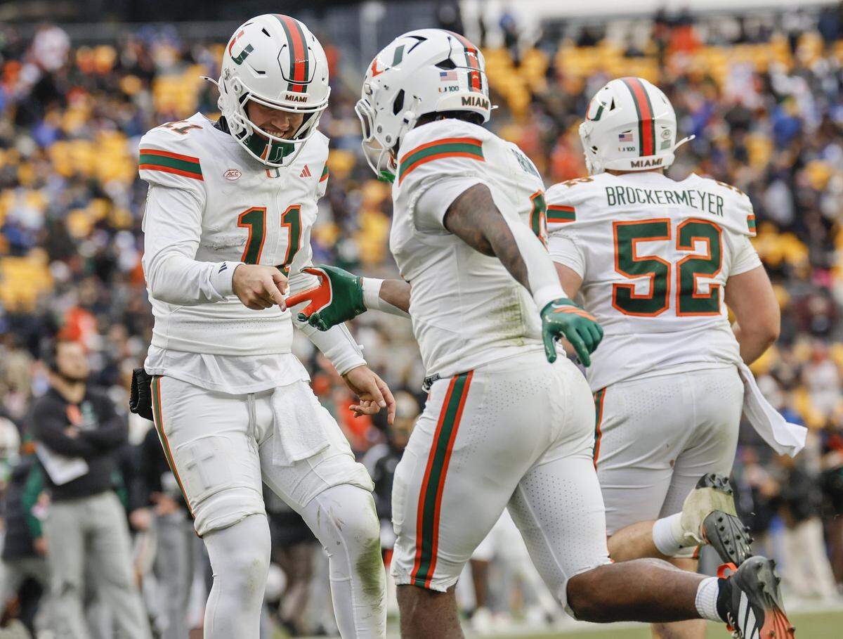 Miami Hurricanes CharMar Brown (9) celebrates with and quarterback Carson Beck (11) after scoring on a 9-yard pass recception in the second half of their NCAA football game at Acrisure Stadium in Pittsburgh, PA, on Saturday, November 29, 2025. 