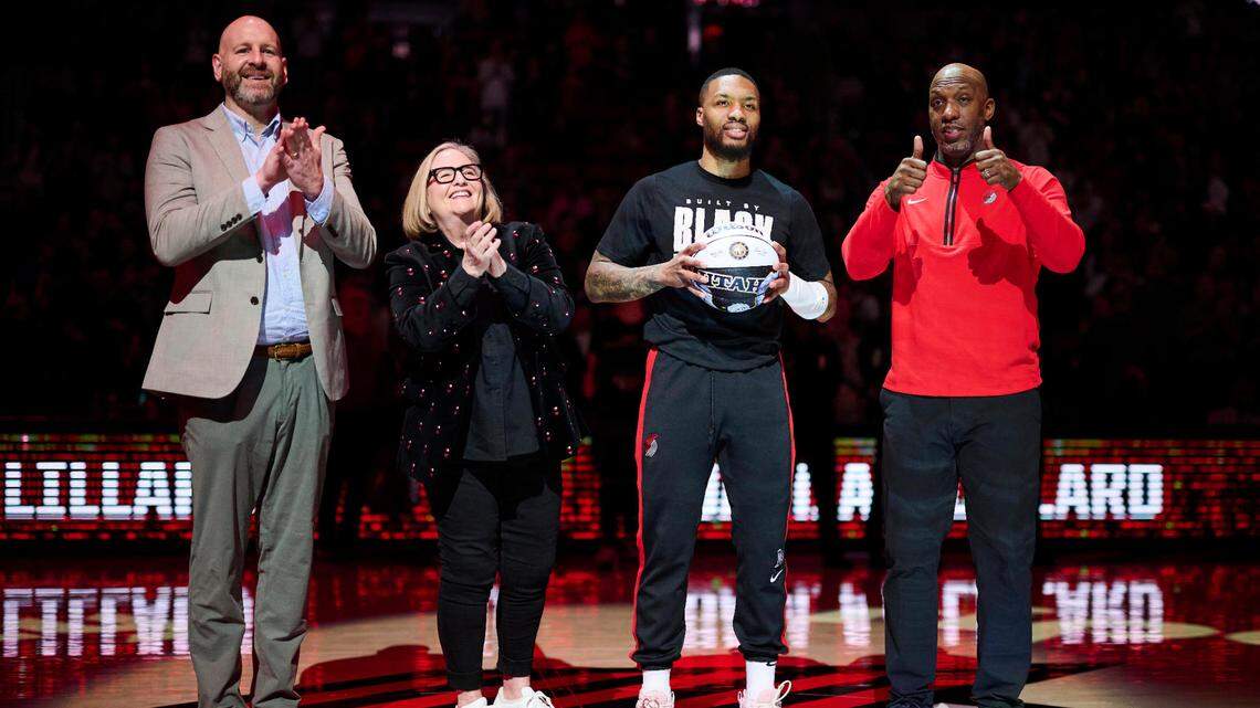 Portland Trail Blazers GM Joe Cronin, left, owner Jody Allen, and head coach Chauncey Billups stand with guard Damian Lillard (0) as he is congratulated on making the NBA All Star team before a game against the Washington Wizards at Moda Center.