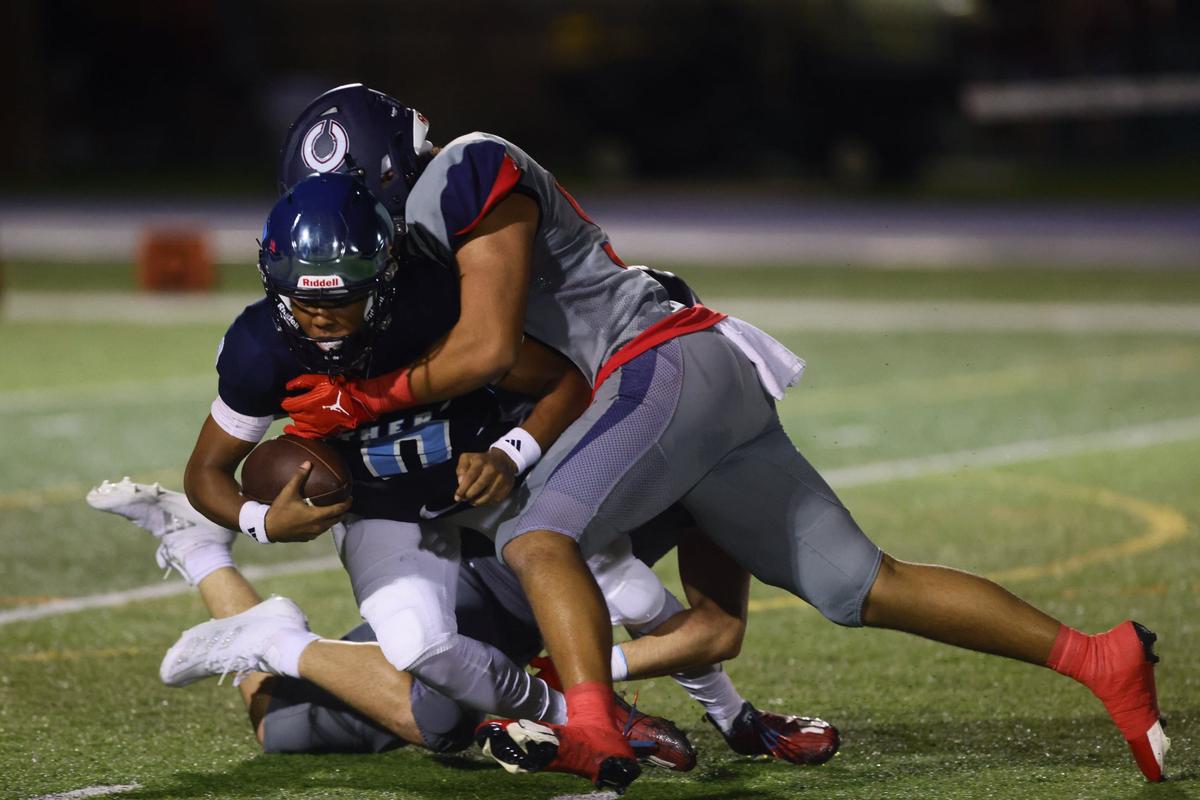 Columbus Explorers defensive lineman Jonathan Nua (92) tackles Palmetto Panthers quarterback Andre Bailey (10) during the first quarter of a high school football game at Tropical Park Stadium in Miami, Florida, on Friday, September 13, 2024.