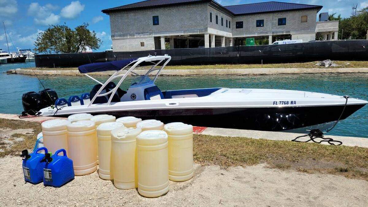 Containers of fuel are set next to a boat that the Monroe County Sheriff’s Office says was stopped off the Florida Keys Saturday, April 18, 2022. Authorities believe the vessel was possibly going to be used for human smuggling.