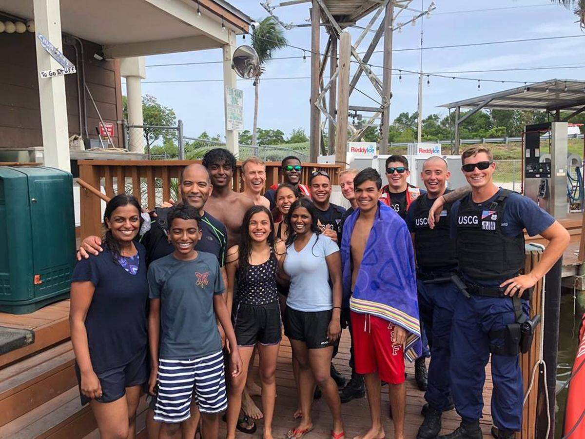 The nine people saved from their sinking vessel off Islamorada Thursday, July 5, 2018, gather for a photo with their rescuers.