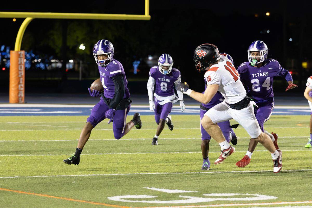 True North’s Malik Penson sweeps around the edge during the Titans’ 62-28 victory over Boca Raton St. Andrews on Thursday night at Tropical Park.