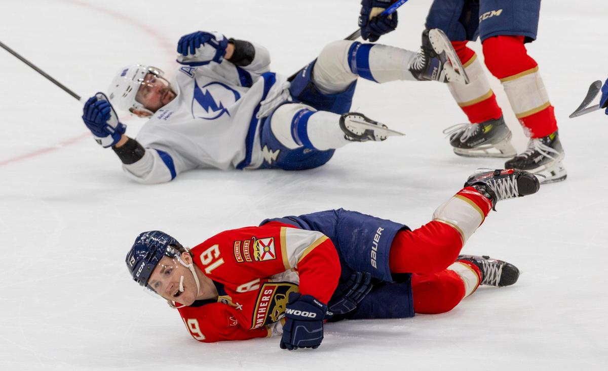Florida Panthers left-wing Matthew Tkachuk (19) lies on the ice after being injured from a hit by Tampa Bay Lightning right-wing Nikita Kucherov (86) during the first period of an NHL game at Amerant Bank Arena on Monday, December 23, 2024, in Sunrise, Florida.