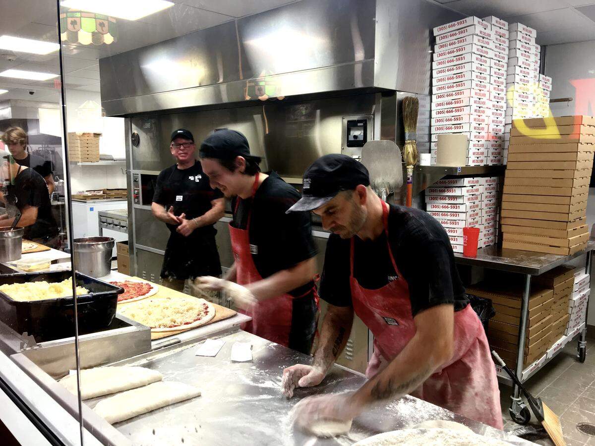 Miami’s Best Pizza, in this June 16, 2018 photo, still has a large glass front kitchen area where you can watch staff toss the pies and sprinkle the toppings and toss them in the ovens, much as you did at the original location since 1970.