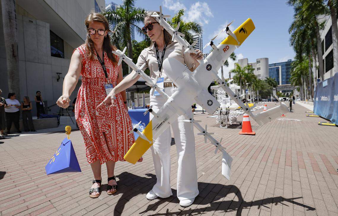 Kendal Prosak and Jessie Poole-Strang demonstrate the Walmart and Wing drone delivery system during CoMOTION Miami, at Miami Dade College's Wolfson Campus in Miami, Florida, on Tuesday, April 28, 2026. Walmart and Wing expect to launch the new drone delivery service in Miami in 2027 as part of its coast to coast expansion plans. Weighing just over 11 pounds, Wing delivery drones cruise at up to 60 mph about 150 feet above the ground. They then hover at about 23 feet to gently lower orders, ensuring safe delivery without spills or cracks. Walmart products eligible for drone delivery include grocery items, household goods and over-the-counter medicine.
