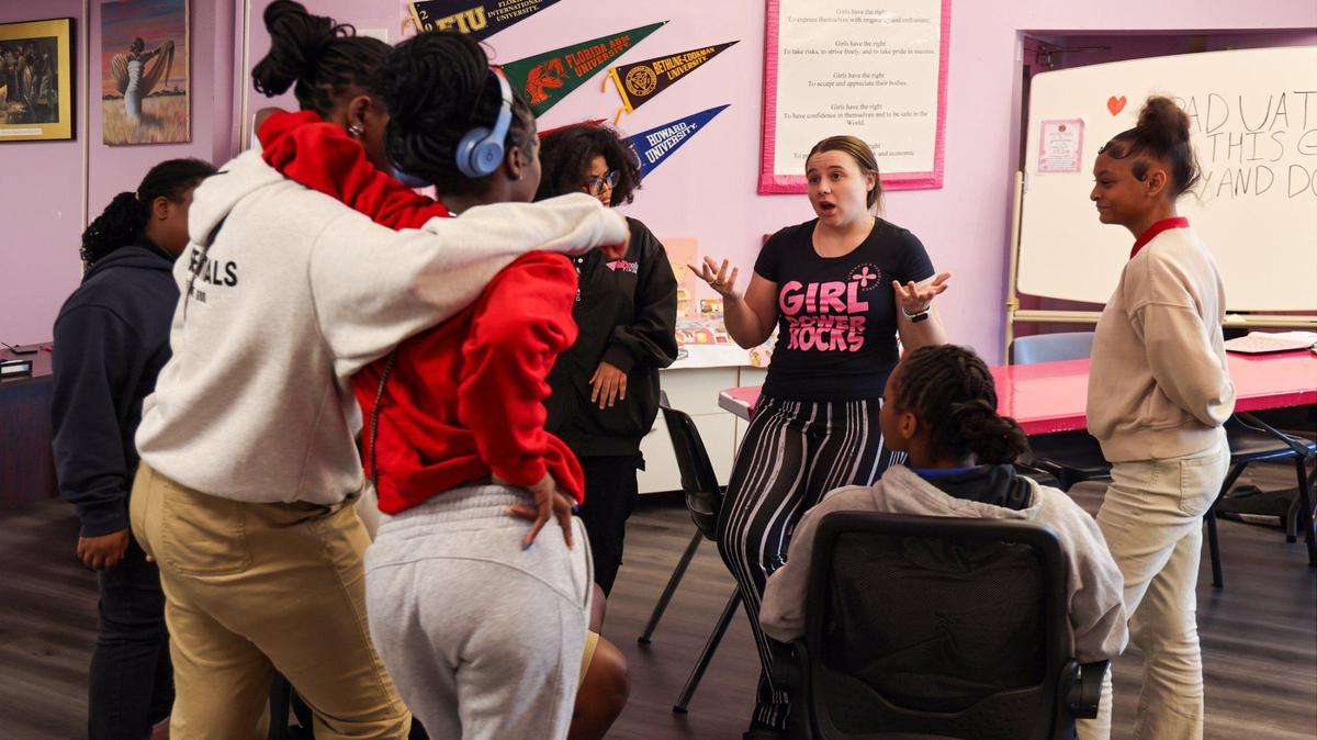 Lexus Barkdoll, a Girl Power Rocks program instructor, center, asks the girls to brainstorm on fundraising ideas as they take a break from working on their essays for graduation on Tuesday, Sept. 24, 2024, in Miami, Florida.