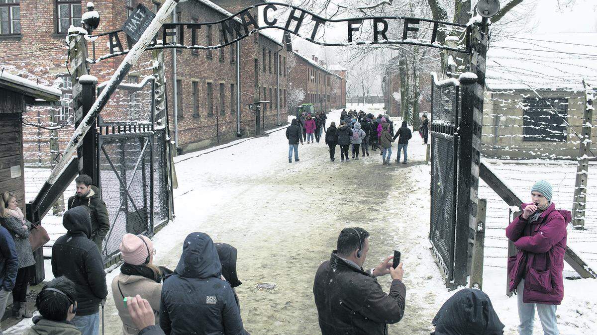 Visitantes frente a la entrada de Auschwitz-Birkenau Memorial and Museum en Oswiecim, Poland. Casi la mitad de los canadienses no pueden nombrar un solo campo de concentración o gueto que existió en Europa durante el Holocausto.