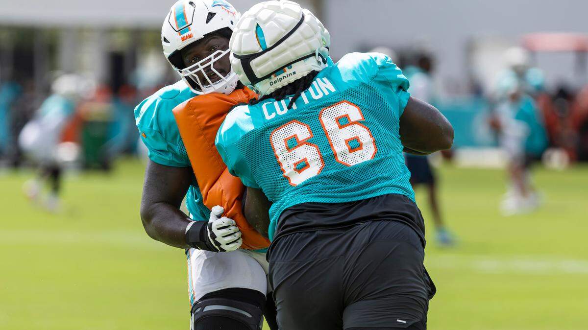 Miami Dolphins guards Lester Cotton (66) and Chasen Hines (63) run drills during a joint practice session with the Atlanta Falcons at the Baptist Health Training Complex on Tuesday, Aug. 6, 2024, in Miami Gardens, Fla.