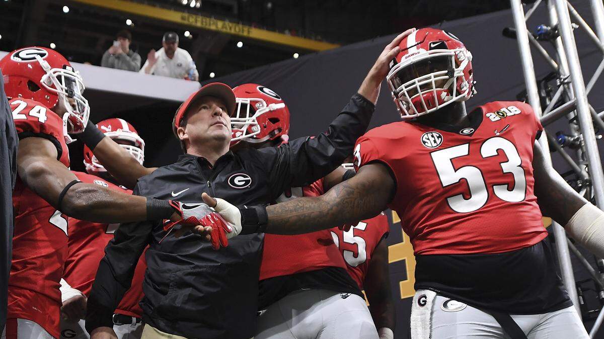 In this Jan. 8, 2017, file photo, Georgia running back Prather Hudson (24), Georgia head coach Kirby Smart, center, and Georgia center Lamont Gaillard (53) take the field before the College Football Playoff National Championship game against Alabama in Atlanta. Neither No. 1 Alabama nor No. 4 Georgia is anxiously awaiting their playoff fates this season, but whoever wins the SEC championship game showdown is definitely in the playoffs. The Crimson Tide could even get in with a close loss.