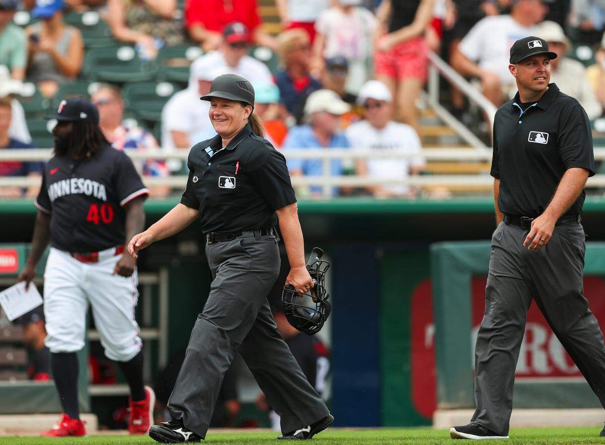 Umpire Jen Pawol (95) smiles while taking the field before a spring training game between the Minnesota Twins and the Colorado Rockies at Lee Health Sports Complex in Fort Myers, Fla., on Tuesday, March 25, 2025.