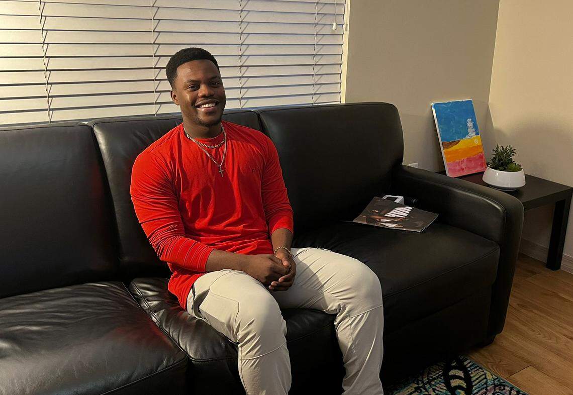 Catule Souverain smiling while sitting on his couch in Casa Valentina’s housing in North Miami.
