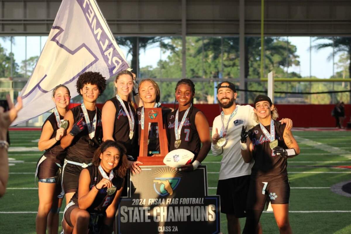 The Miami Palmetto flag football coach Kevin Mujica celebrates with his players after they won their first ever state championship following a thrilling 26-25 win over Lennard on Saturday in Tampa, Fla.