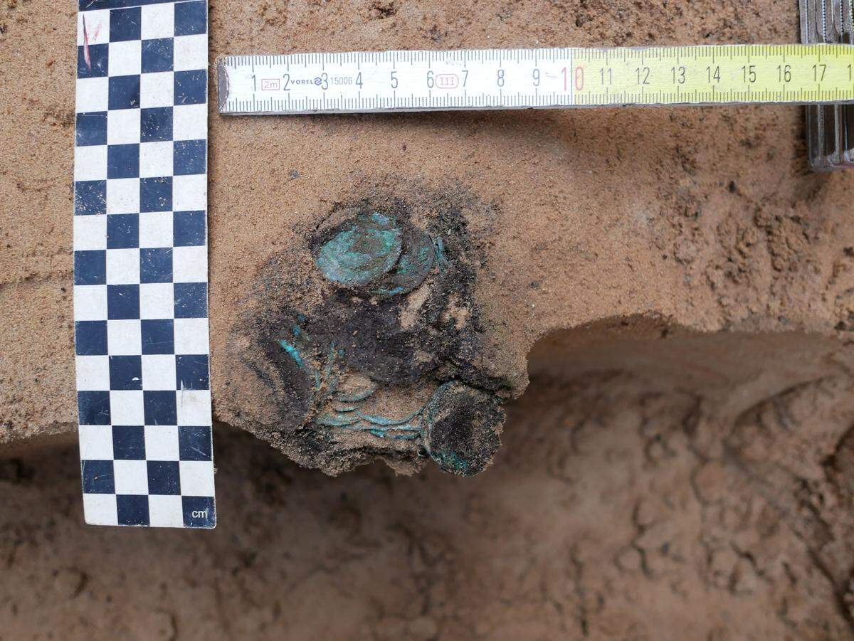 The coins have a green patina because they are made of copper and silver, according to experts.