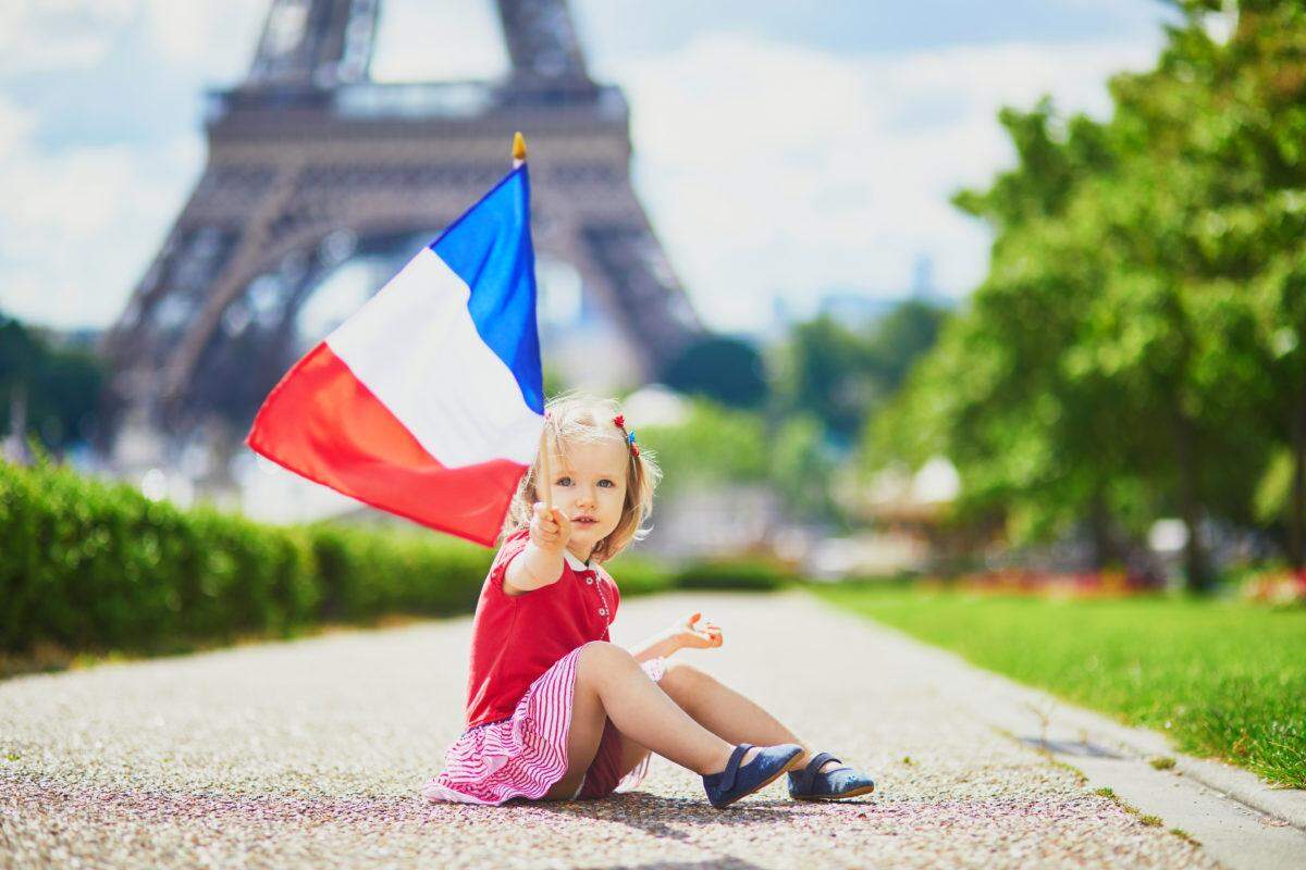 young girl holding france flag near eiffel tower