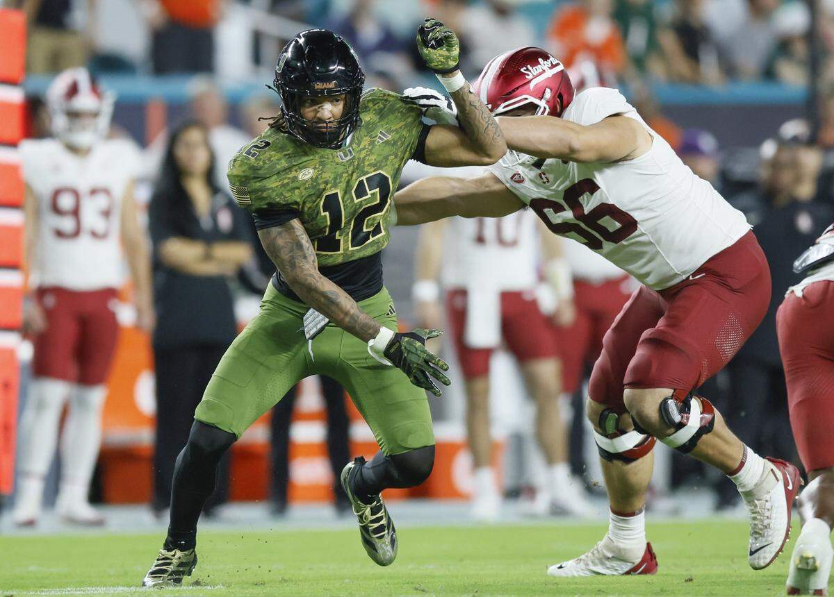 Miami Hurricanes defensive lineman Marquise Lightfoot (12) pushes his way pass the line of scrimmage as Stanford Cardinal offensive lineman Niki Prongos (66) defends in the first half during their NCAA football game at Hard Rock Stadium in Miami Gardens, Florida, on Saturday, October 25, 2025.